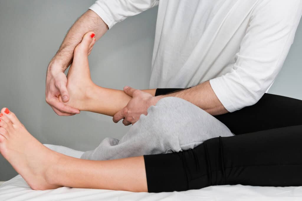 physical therapist's adjustment of patient's foot