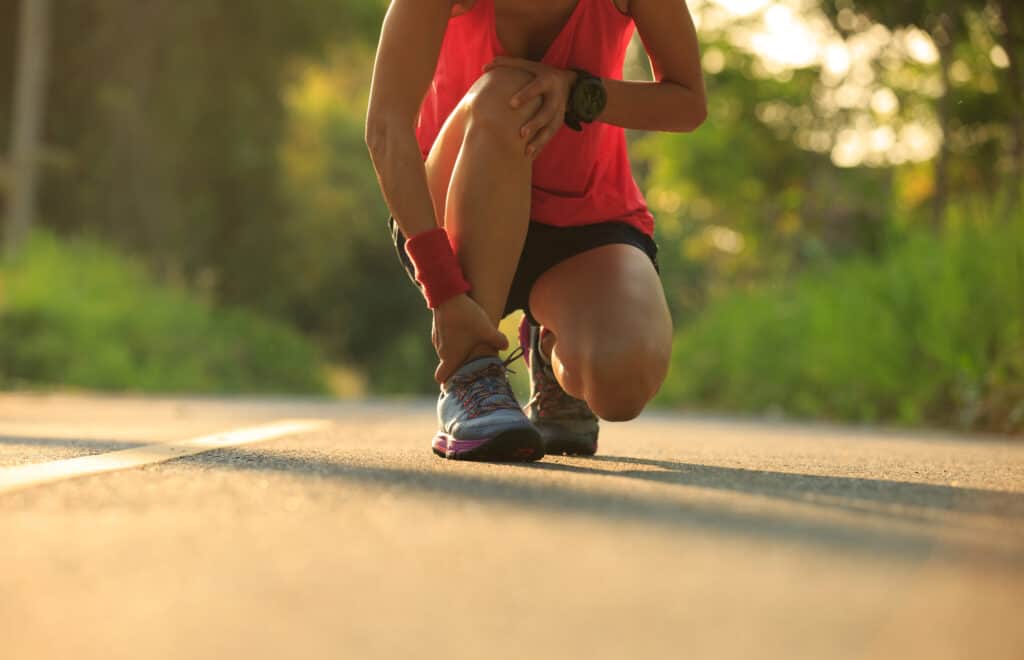 young fitness woman runner got sports injury on knee and legs