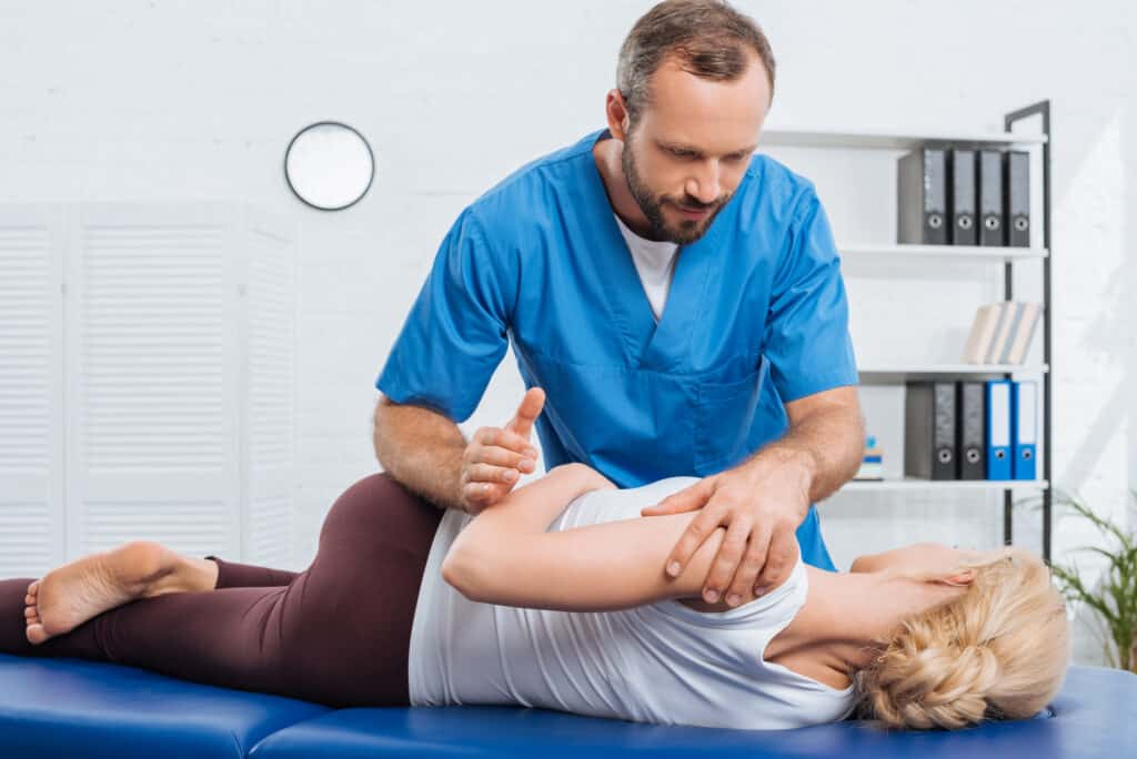 man giving physical therapy to woman lying on table 